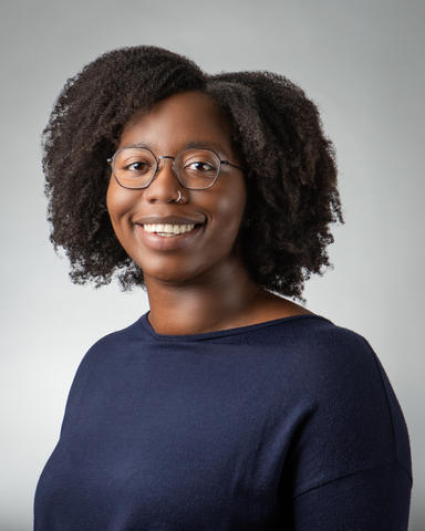 Image of a black woman with natural hair in a dark blue shirt