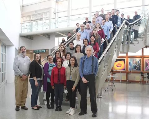 Staff gather, standing on the steps for a large group photo