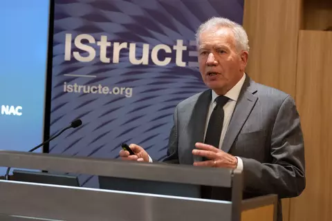 Glenn Bell speaks at a podium with an IStructE banner behind him. 