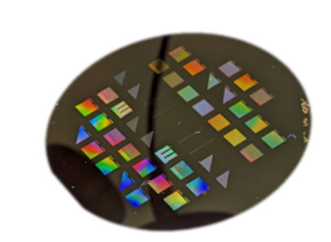 Black disk has multicolored squares and triangles on its surface. 