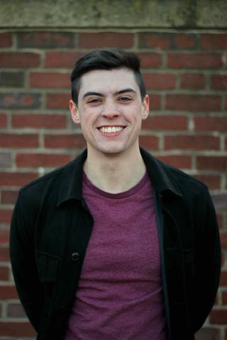 Headshot of Dr. Ryan Steed against brick background.