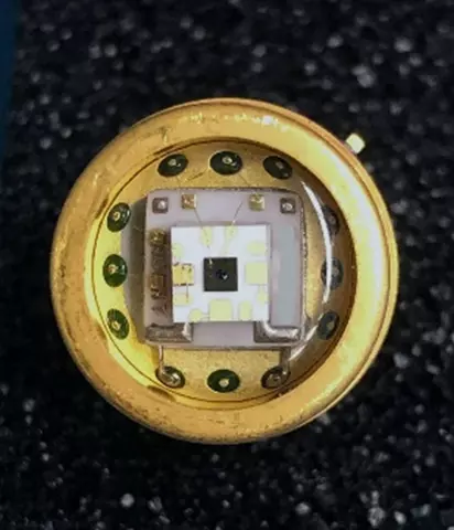 Square chip is fixed to a round metal surface. 