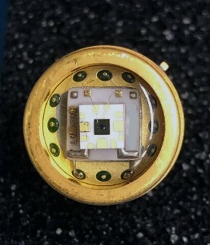 Square chip is fixed to a round metal surface. 