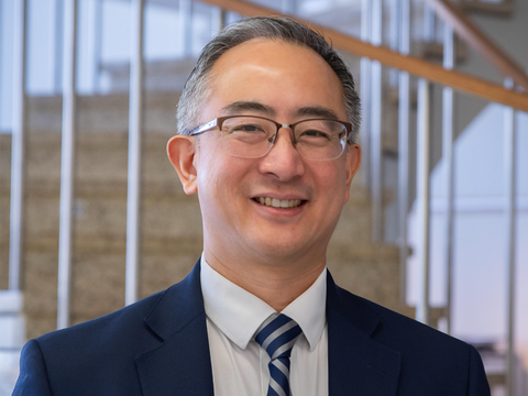 Eric Lin headshot in front of a staircase
