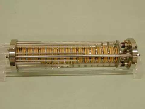 A cylindrical device is made up of adjustable disks with metal attachments on either end. 