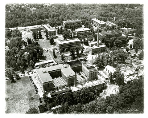 Historical aerial view of the National Bureau of Standards campus surrounded by trees.