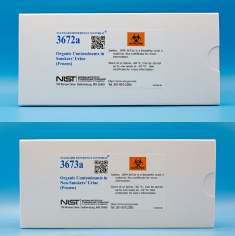 Two white cardboard boxes with white labels that contain blue text that reads  "Organic contaminants in smokers' urine"  One box displays Standard reference material 3672a and other 3673a