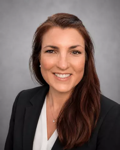 May 2026 professional headshot of Colleen Bryan with long brunette hair wearing a black blazer and white blouse