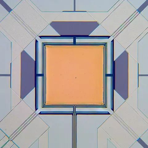 Micrograph of yellow square with lines attached to each corner.