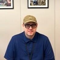 Sean Lehman sitting and posing for a headshot in a meeting room.