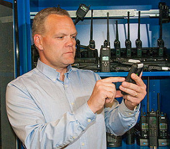 Dereck Orr with a variety of radios and cell phones