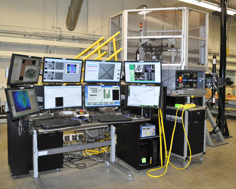 Image of cruciform testing frame control system during a cruciform biaxial test with tesing machin in the background.