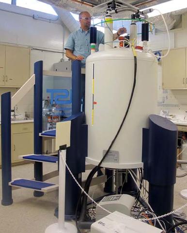 A researcher inserts a sample into the 600 MHz NMR spectrometer.