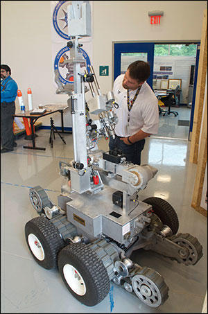 Matthew Hickman, Department of Homeland Security Program Manager, with a Remotec Andros bomb-disposal robot.