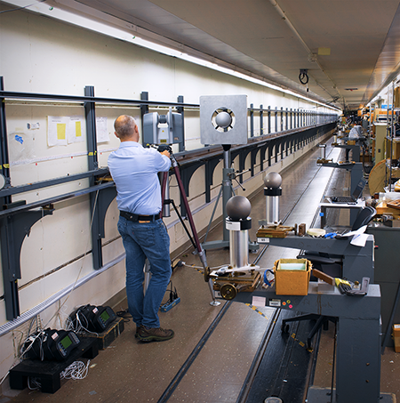 A participant performing relative range measurements in the long length tape tunnel facility at NIST. 