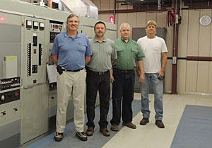 NIST engineer Matthew Deutch and technicians Douglas Sutton, Glenn Nelson, and Bill Yates (left to right) are shown with one of three WWVB transmitters as it broadcasts the station's signal in 2013.