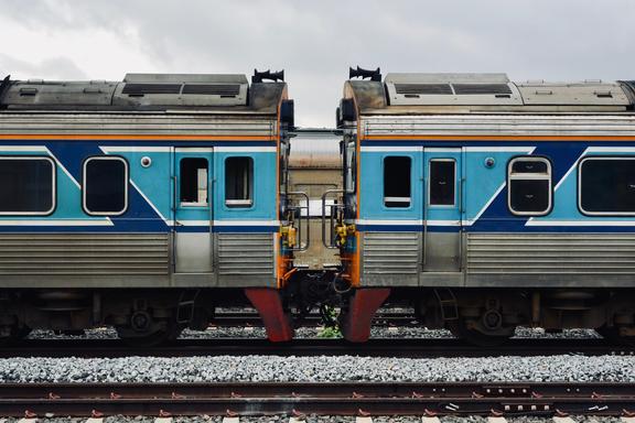 A detailed view of two connected blue and silver train cars on a railway track.
