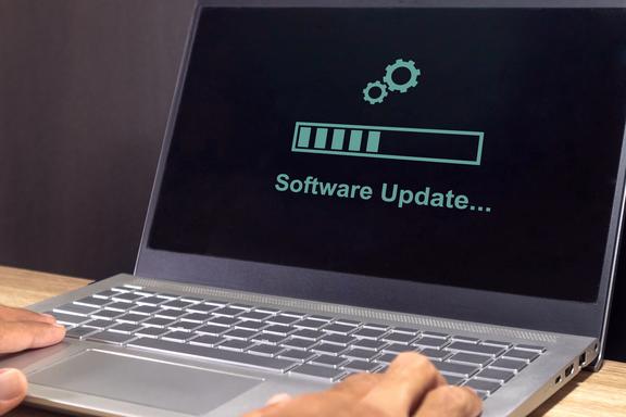 A laptop screen displays the words “software update” with a progress bar. 