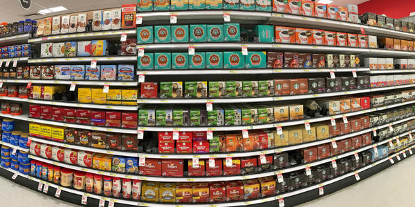 Fisheye view of grocery store shelves packed with coffee products.