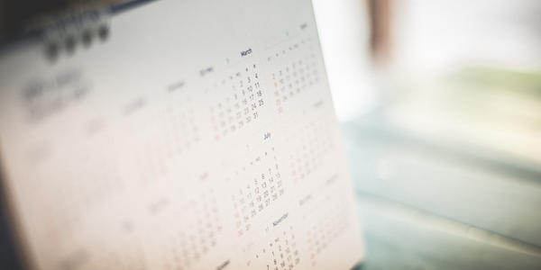 A spiral-bound calendar page is blurred at the edges. 