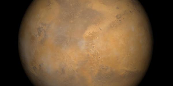 Color-enhanced photo of Mars shows the planet with patches of orange and brown. 