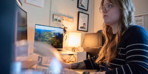Sierra Miller sits at a desk facing a computer screen.