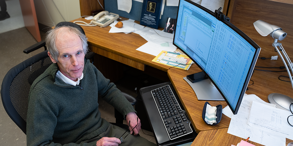 Alexander Kramida looks up as he sits at his desk in front of a computer screen full of data.