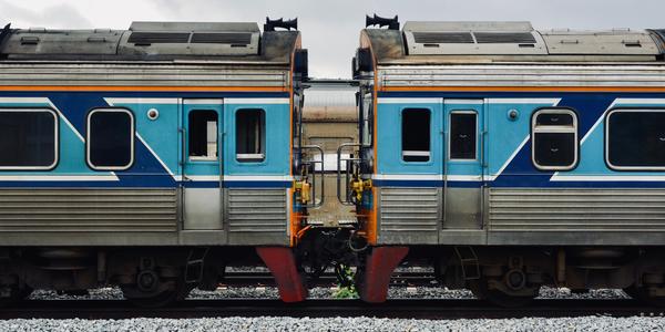 A detailed view of two connected blue and silver train cars on a railway track.