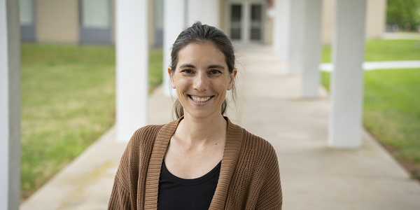 Stephanie Servetas poses smiling outdoors on the NIST Gaithersburg campus.