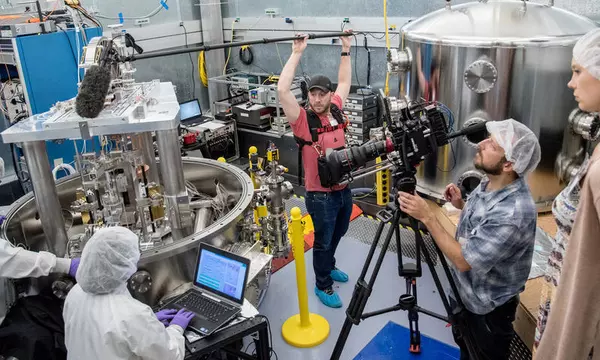 Film crew films a pair NIST researchers operating the NIST Kibble balance