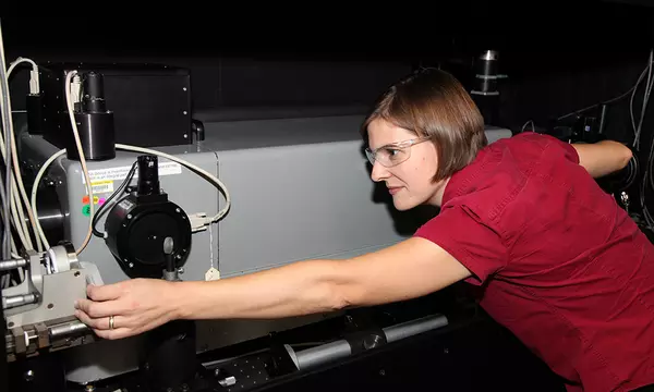 Catherine Cooksey adjusting a machine for the measurement of transmittance. 