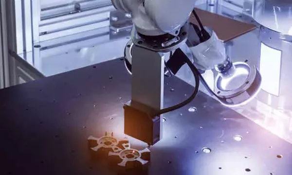 robotic arm with 3D printed parts on a table in a manufacturing facility