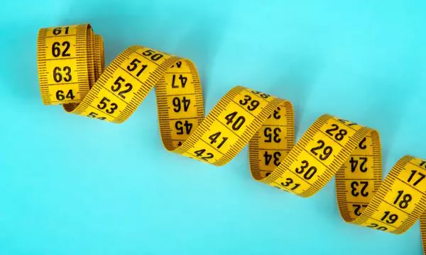 blue backgrond with a coiled yellow metric tape measure