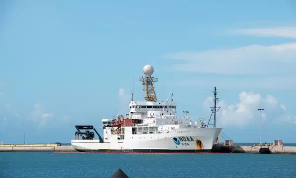 Photograph of a NOAA research vessel on blue water against a blue sky