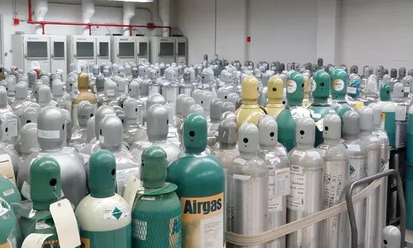 Photograph of hundreds of gas cylinders in a gas storage facility.