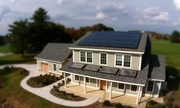 A newly built two-story home with an attached garage has solar panels on the roof.