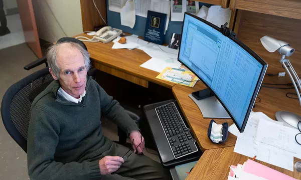 Alexander Kramida looks up as he sits at his desk in front of a computer screen full of data.