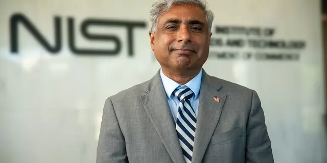 NIST director standing in front of the NIST logo