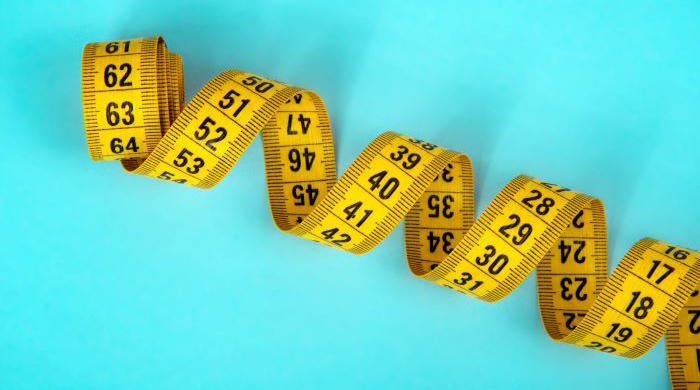 blue backgrond with a coiled yellow metric tape measure