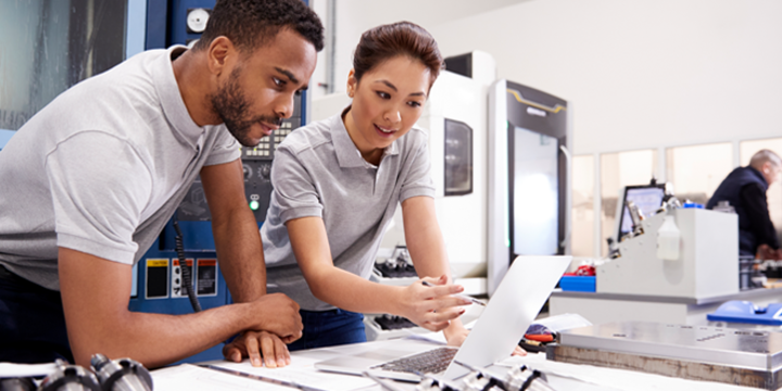 Two Engineers Using CAD Programming Software On Laptop