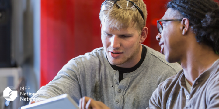 Two young men participating in manufacturing workforce training.