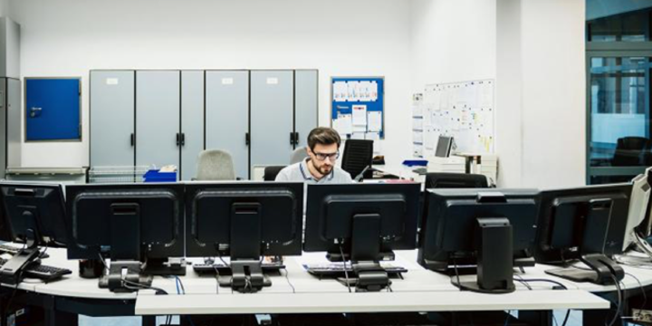 man sitting at computers in a cybersecurity center