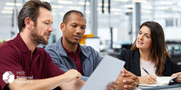 supervisor and employees having meeting in manufacturing facility