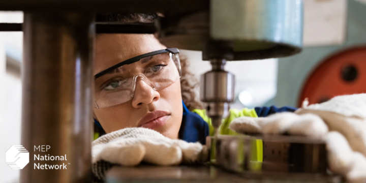 Female apprentice using yoke machine in factory