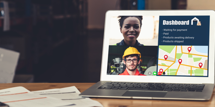 Warehouse staff talking on video call at computer screen in storage warehouse