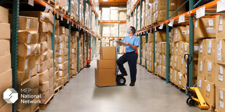 Warehouse Worker Checking Inventory Wearing Protective Mask