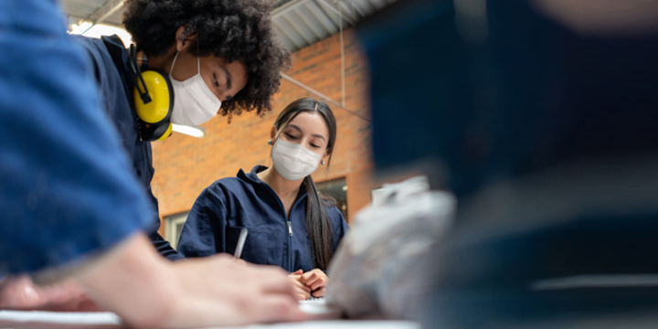 Students in a manufacturing class at school wearing facemasks 