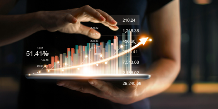 Businessman holding tablet and showing a growing virtual hologram of statistics, graph and chart with arrow up on dark background. 