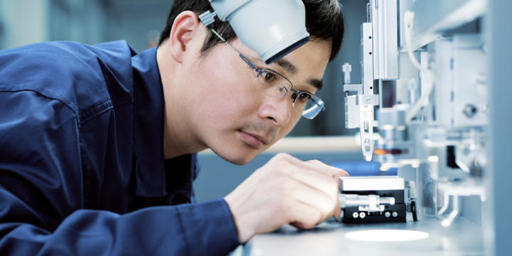 Quality inspection worker looking at a product under a microscope