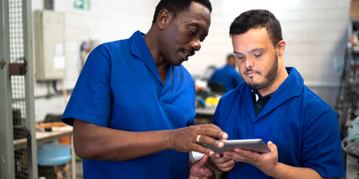 Colleagues using digital tablet and working in industry